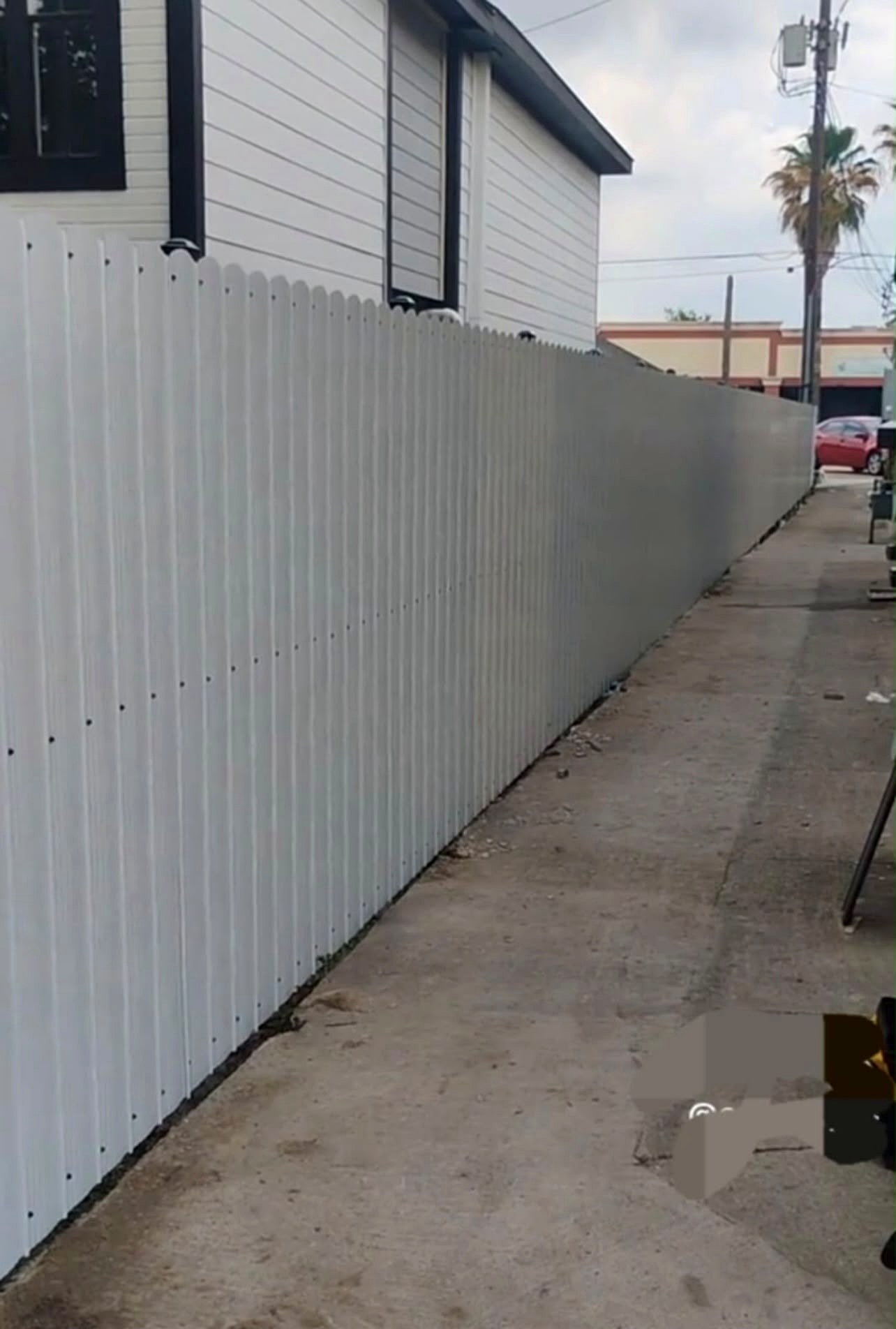 White metal privacy fence finished along property